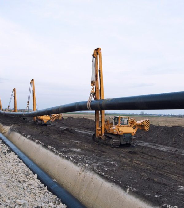 heavy-duty-construction-machines-carrying-placing-gas-pipe-into-ground_342744-367